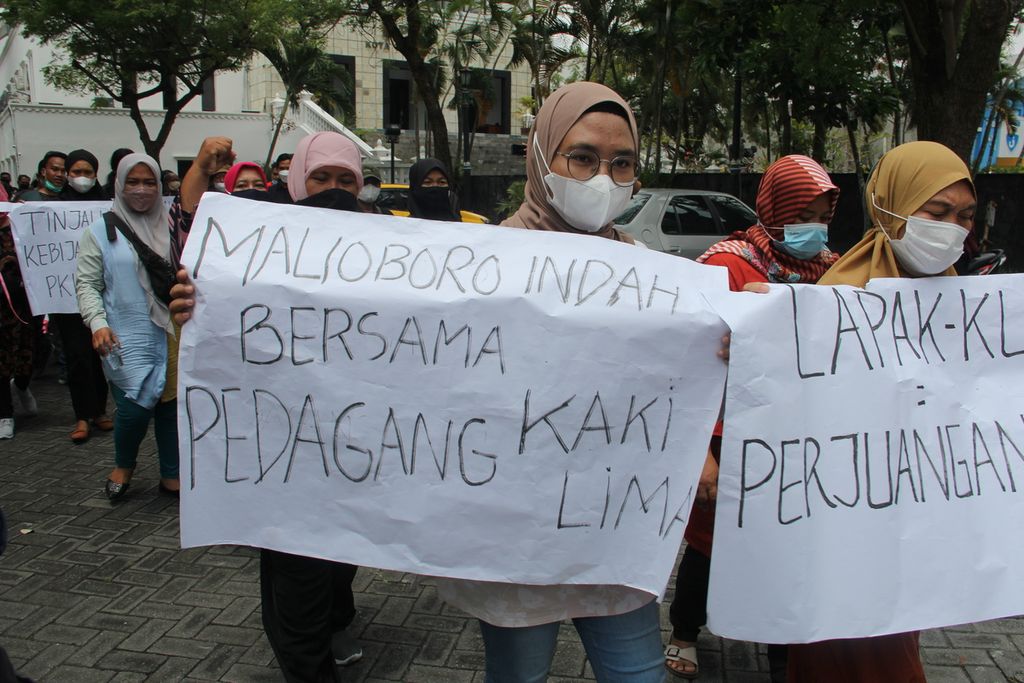 Sejumlah pedagang kaki lima (PKL) kawasan wisata Malioboro, Kota Yogyakarta, membentangkan poster di halaman Gedung DPRD Kota Yogyakarta, Senin (17/1/2022). 