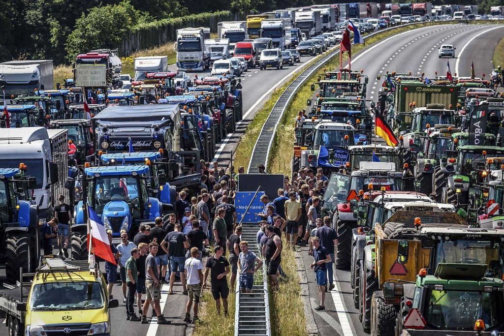 Para petani memarkir traktor mereka di jalur bebas hambatan di perbatasan Belanda-Jerman tak jauh dari Rijssen pada Rabu (29/6/2022).