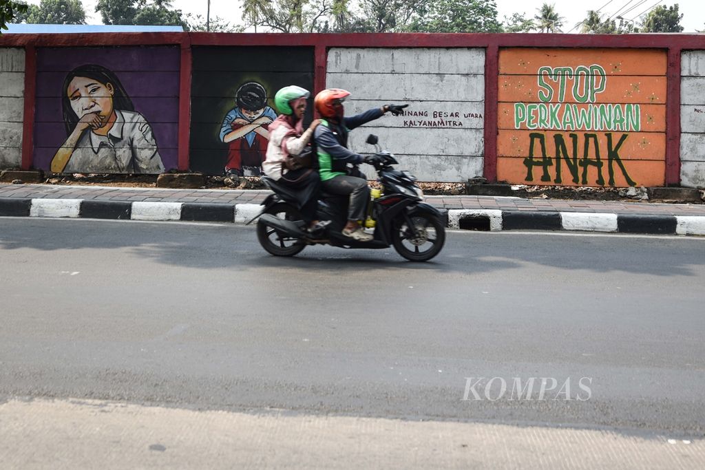 Mural bertemakan penolakan terhadap perkawinan anak menghiasi dinding tembok pembatas antara rel kereta api dan jalan raya di Jalan Bekasi Timur, Jakarta Timur, Sabtu (28/9/2019). 