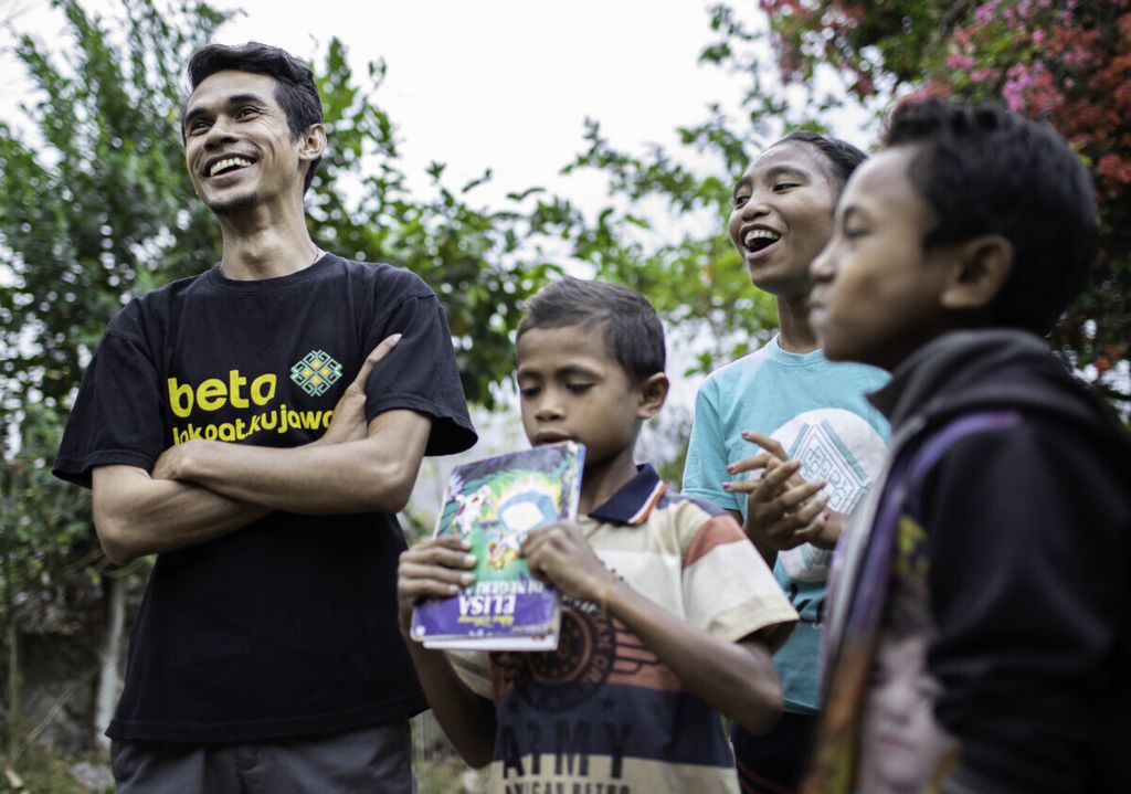 The founder of Lakoat.Kujawas, Dicky Senda (left), smiling with the children.