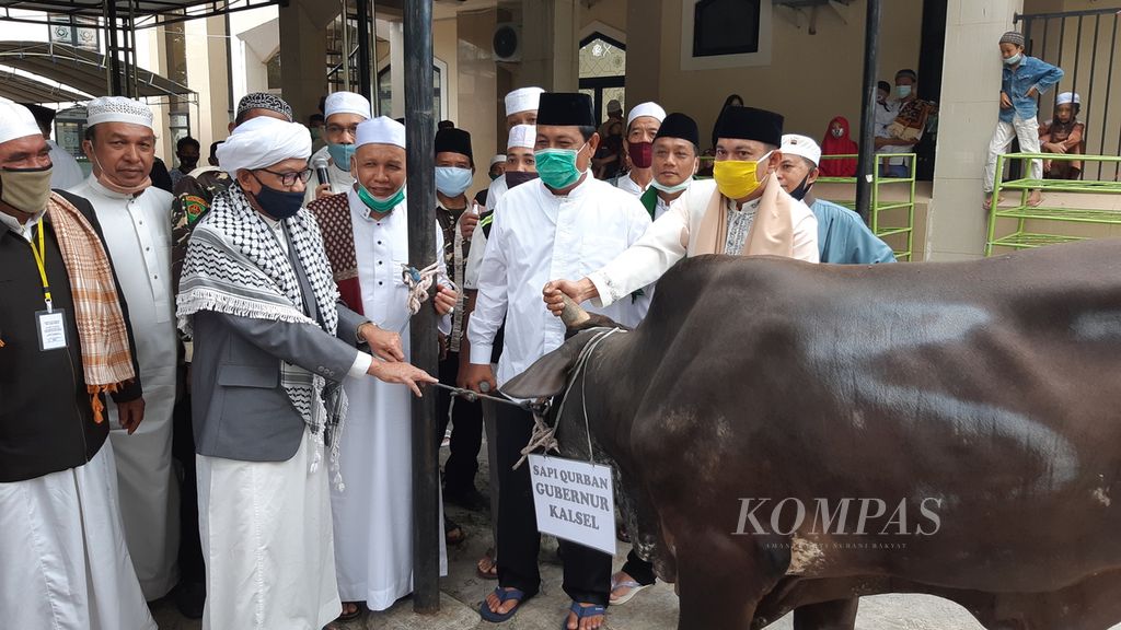 Gubernur Kalimantan Selatan Sahbirin Noor (depan, kedua dari kanan) menyerahkan hewan kurban kepada pengurus Masjid Raya Sabilal Muhtadin, Banjarmasin, seusai menunaikan shalat Idul Adha 1441 Hijriah di masjid tersebut, 31 Juli 2020.