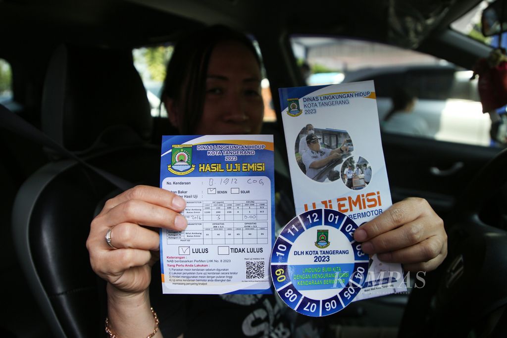 Motorists show the results of their vehicle's emissions test after taking a free emissions test at Benteng Stadium, Tangerang City, Banten, Wednesday (6/9/2023). 