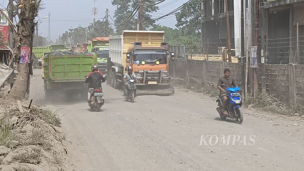 Kondisi lalu lintas di Jalan Mohamad Toha, Parung Panjang, Kabupaten Bogor, Selasa (12/12/2023), berdebu. Truk muatan tambang masih beroperasi meski sudah ada aturan pembatasan jam operasional.