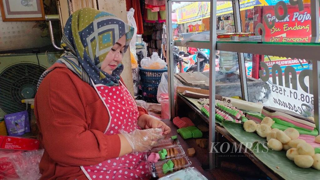 Rifah, salah seorang produsen getuk, memotong-motong getuk sesuai permintaan pelanggan yang datang ke kiosnya di Pasar Rejowinangun, Kota Magelang, Rabu (12/4/2023).