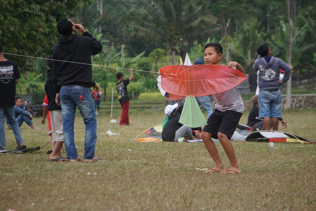 Anak-anak bermain layangan di lapangan Desa Karangmangu, Kecamatan Baturraden, Kabupaten Banyumas, Jawa Tengah, Minggu (3/9/2023).