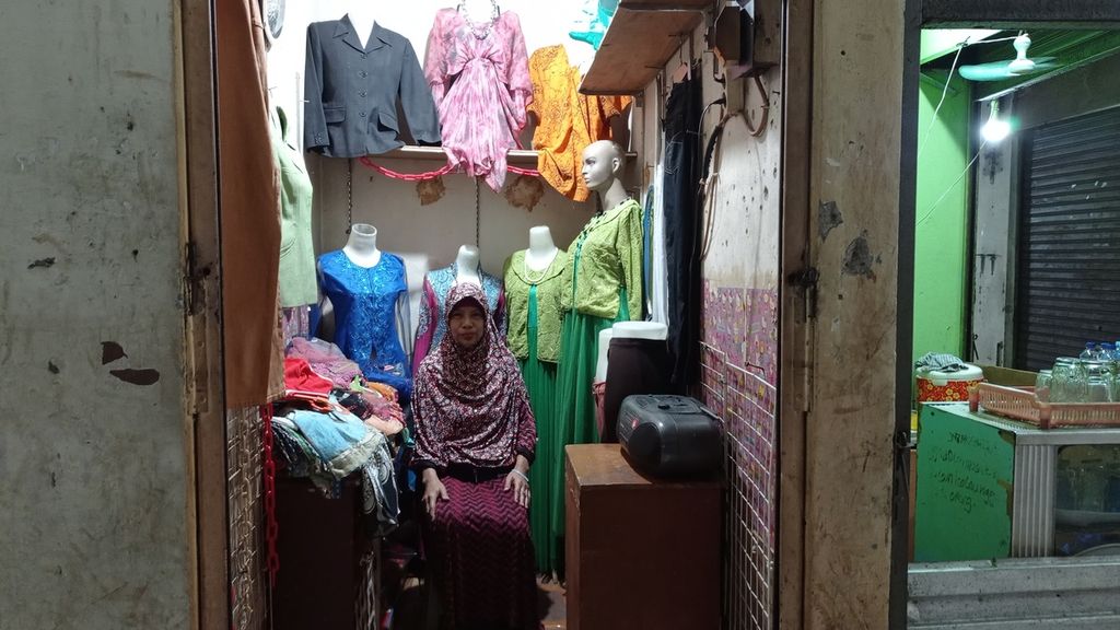 Pedagang busana menanti pembeli di kiosnya di Blok G Pasar Tanah Abang, Jakarta Pusat, Jumat (14/7/2023). Pedagang mengeluhkan aksesibilitas ke pasar yang sulit dan kondisi pasar tak terurus.