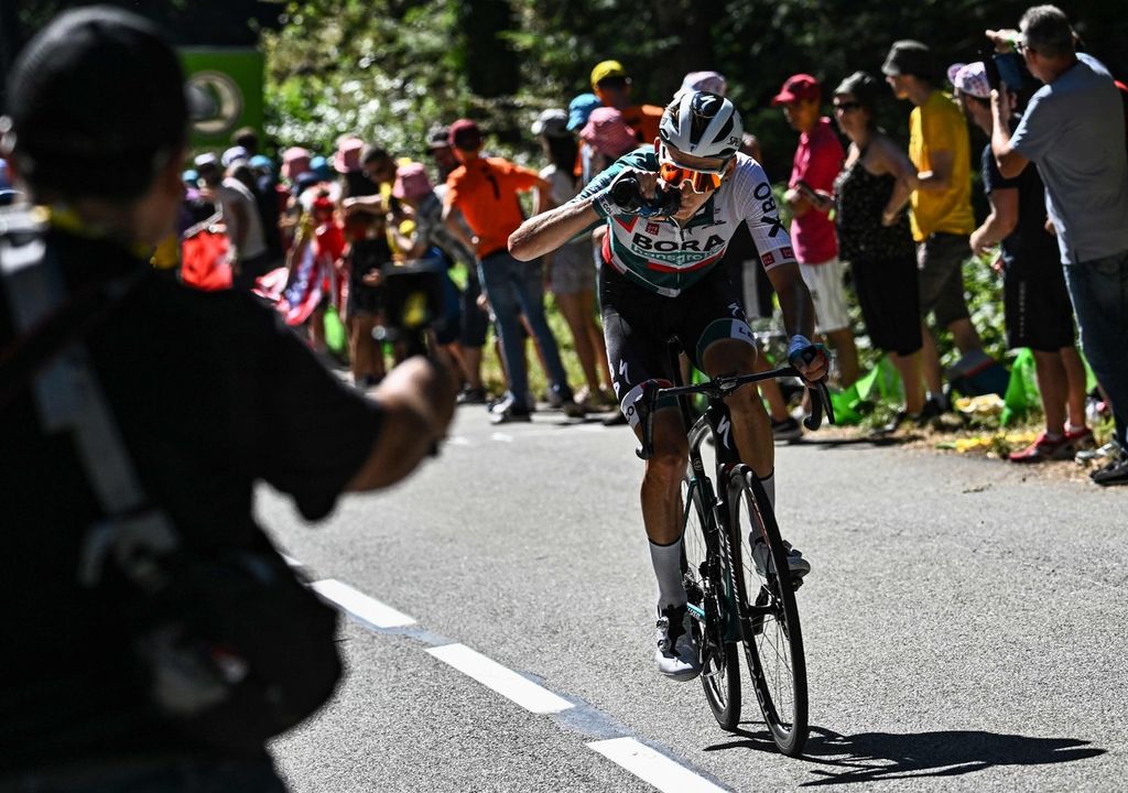 Pebalap Bora-Hansgrohe asal Jerman, Lennard Kamna, meminum air dari botol saat etape ke-7 Tour de France, 8 Juli 2022. 