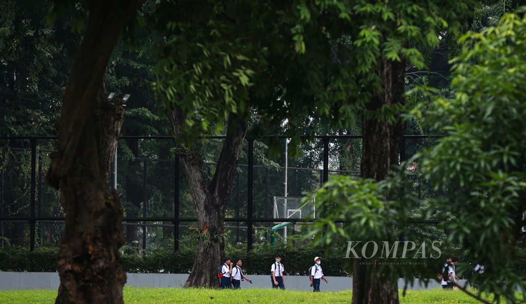 Pelajar melintas di Lapangan Banteng, Jakarta Pusat, Senin (13/6/2022). Kasus Covid-19 di Indonesia meningkat dalam sepekan terakhir di tengah ditemukannnya subvarian Omicron BA.4 dan BA.5.