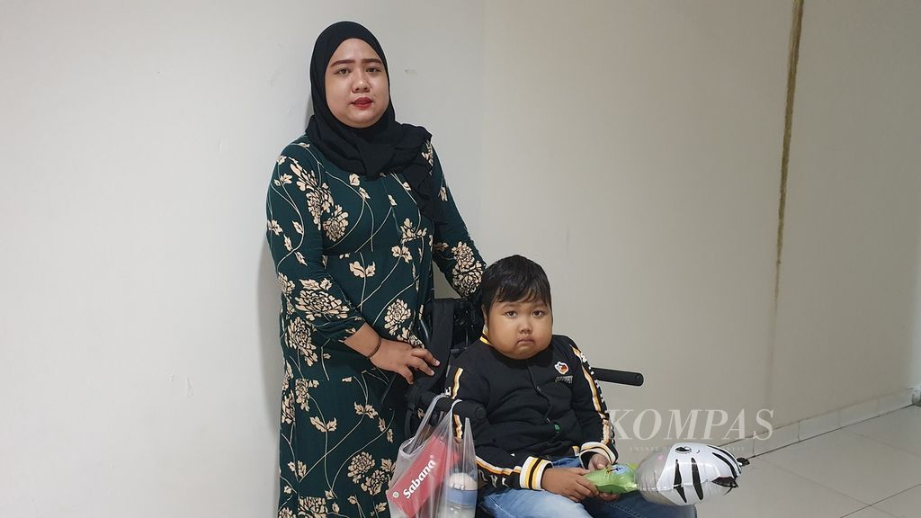 Faris (8) dan ibunya, Dewi Ningrum (29), saat menunggu antrean cuci darah di Ruang Dialisis, Lantai 5, Gedung Kiara, Rumah Sakit Cipto Mangunkusumo (RSCM), Jakarta Pusat, Kamis (25/7/2024).