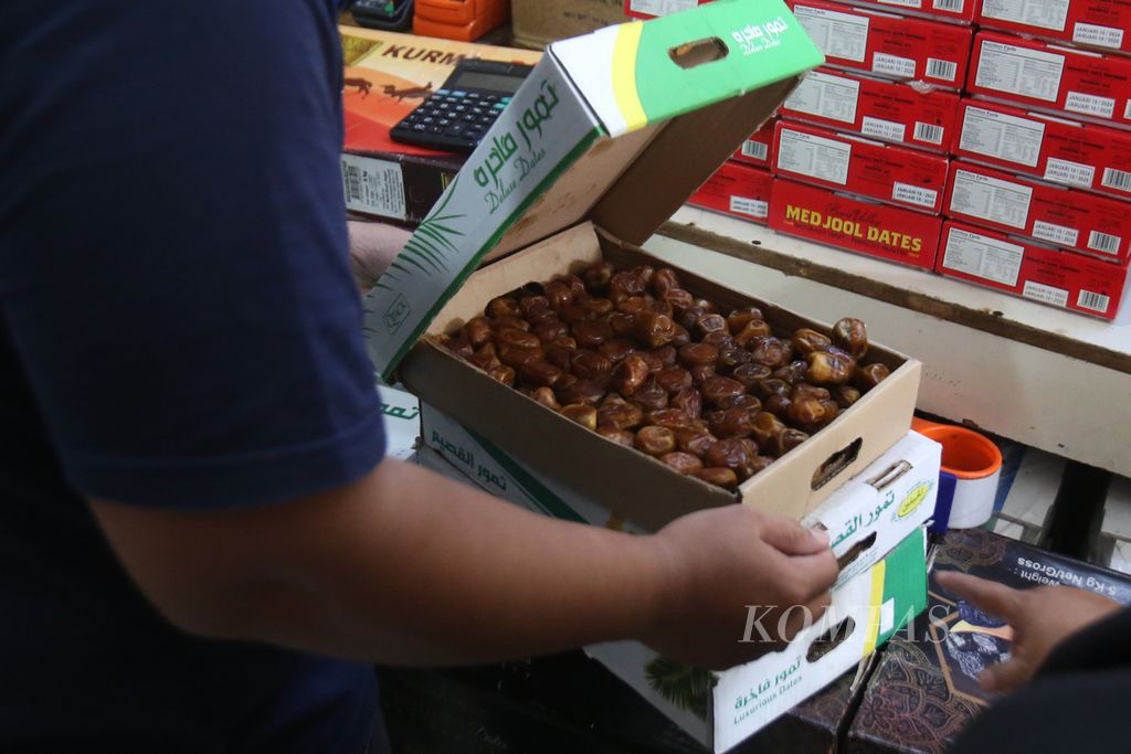 Pegawai toko oleh-oleh haji dan umrah di kawasan Tanah Abang, Jakarta, menyiapkan buah kurma pesanan pelanggan, Jumat (15/3/2024).