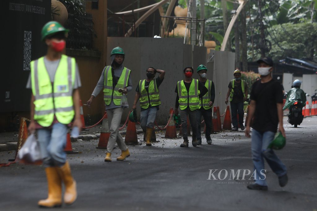 Pekerja meninggalkan lokasi proyek pembangunan sarana transportasi umum di Setiabudi, Jakarta, Selasa (22/2/2022). 