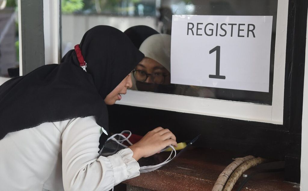 Peserta tes CPNS Kota Surabaya mendengarkan arahan panitia saat mendaftar ulang di GOR Pancasila, Surabaya, Jawa Timur, Selasa (21/9/2021). 