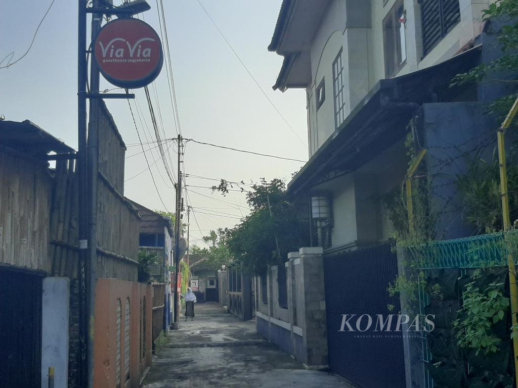 Papan nama penginapan terlihat tinggi di antara bangunan rumah penduduk di gang sempit di Kampung Prawirotaman, Yogyakarta, Sabtu (7/5/2022).
