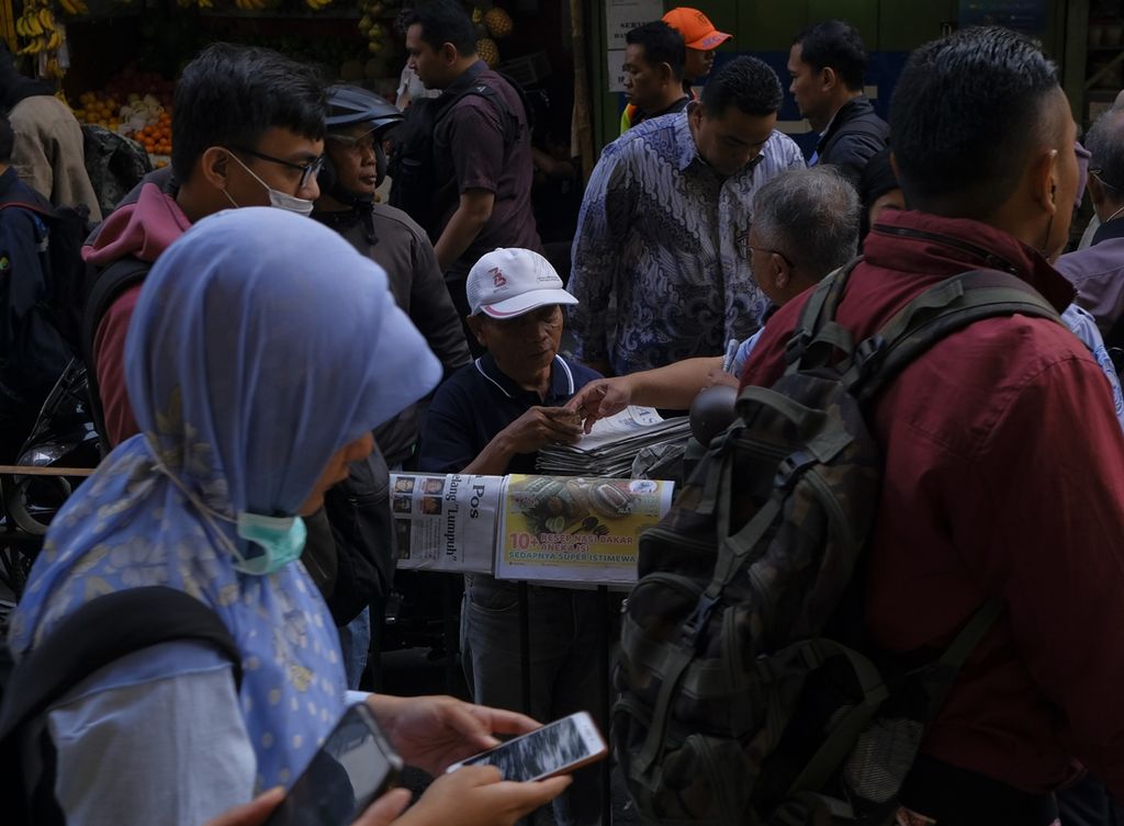 Anen (54), seorang loper koran di Stasiun Gondangdia, Jakarta, berada di tengah kerumunan warga, Kamis (17/10/2019).
