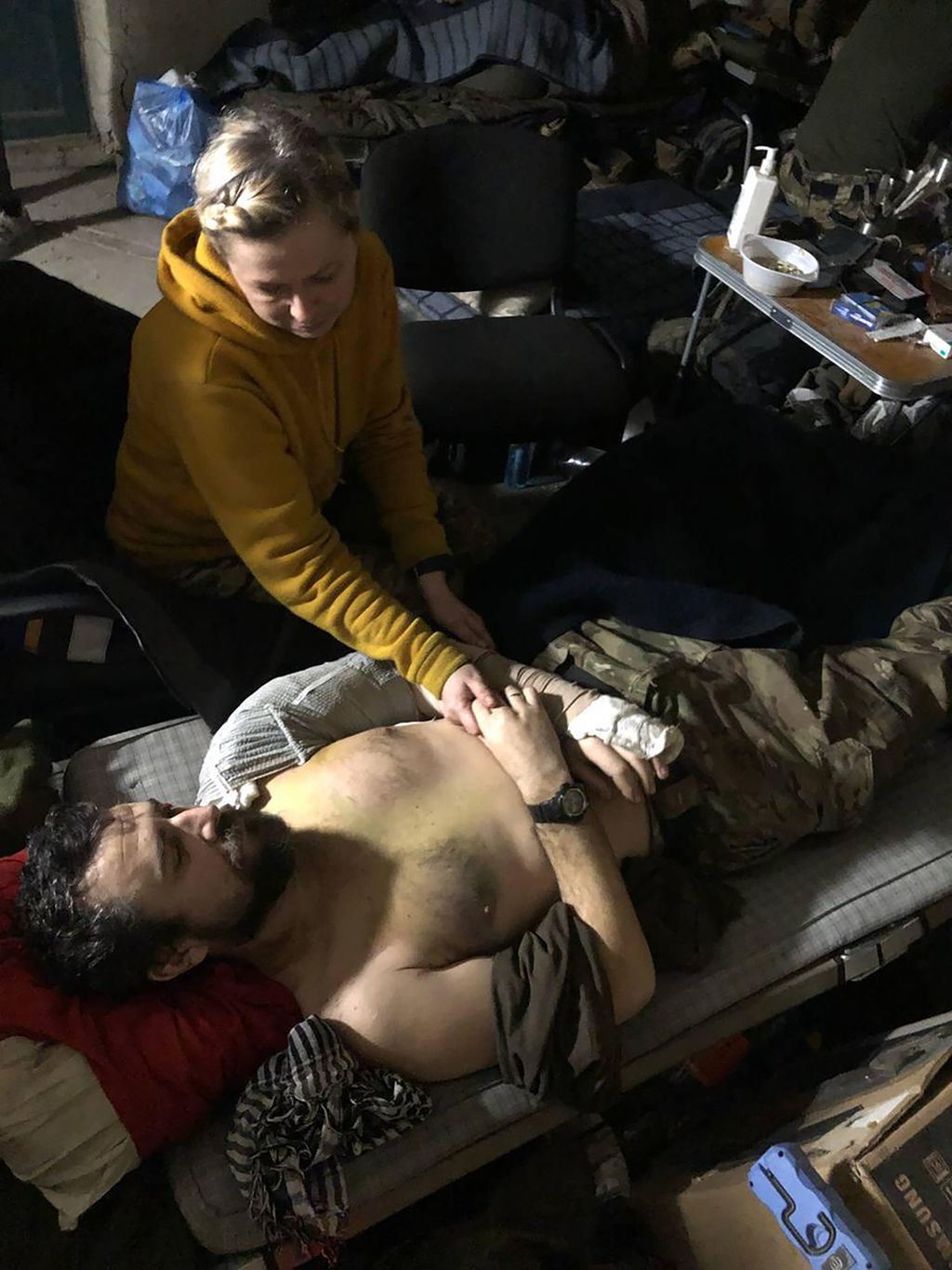 Dalam foto tanpa tanggal, yang diberikan oleh istri seorang anggota Resimen Azov pada Jumat (29/4/2022) terlihat seorang perempuan tengah merawat seorang pria terluka di dalam pabrik baja Azovstal, Mariupol, Ukraina tenggara. 