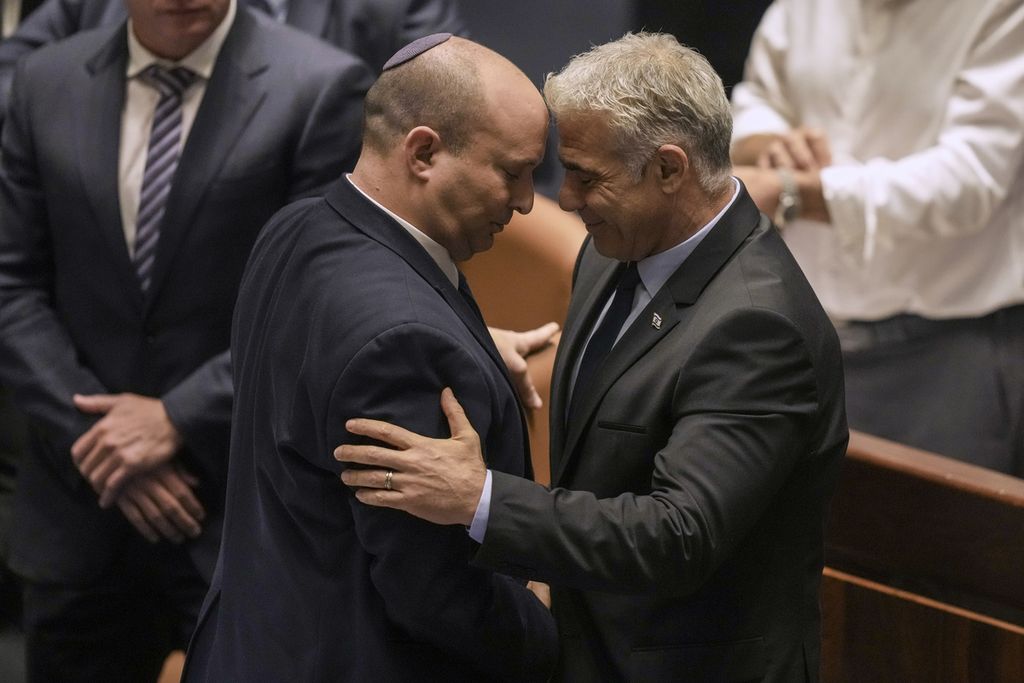 Perdana Menteri Israel Naftali Bennett (kiri) dan Menteri Luar Negeri Israel Yair Lapid berhadapan setelah pemungutan suara untuk pembubaran parlemen di Knesset, Jerusalem, 30 Juni 2022. Lapid kini menjadi PM Israel sementara hingga pemilu November mendatang.