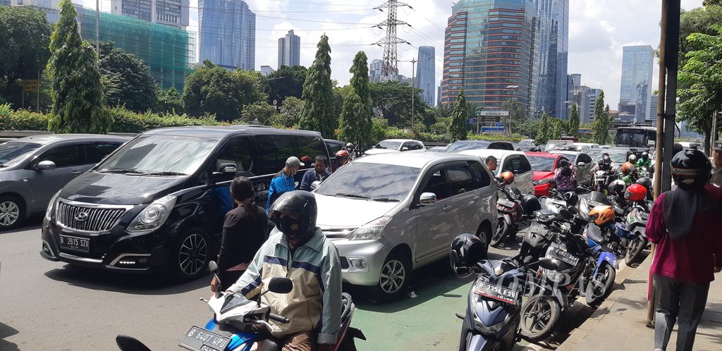 Sejumlah kendaraan terparkir di bahu Jalan Gatot Subroto arah Slipi, Jakarta Selatan, Senin (3/4/2023). Kendaraan milik pengunjung Polda Metro Jaya tidak bisa dibawa masuk karena aksesnya ditutup bersamaan dengan acara serah terima jabatan kepala Polda Metro Jaya yang baru. Kondisi ini memperparah kemacetan jalan di sekitarnya.