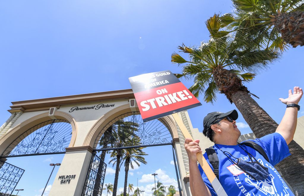 Seorang demonstran memegang plakat di depan Paramount Studios saat mogok para penulis naskah di Los Angeles, California, Amerika Serikat, 2 Mei 2023. Para aktor akan menyusul mogok seperti para penulis naskah jika kesepakatan tidak tercapai sesuai tenggat. 