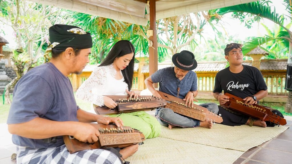 Yura Yunita (berbaju putih) dan Ridho Hafiedz (bertopi) memainkan alat musik tradisional Bali dalam film dokumenter berjudul Nada-nada Penting (The Most Important Serenade).