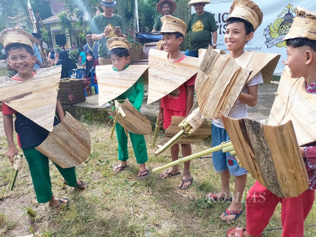 Anak-anak yang bertugas sebagai petugas kebersihan di Liga Pisang Borobudur 2022 berkumpul dengan mengenakan "seragam" berupa kostum yang terbuat dari pelepah pisang kering, Rabu (25/5/2022).