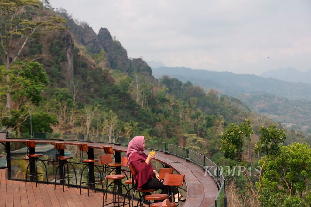 Pengunjung menikmati keindahan panorama perdesaan dan beberapa gunung yang terlihat dari di Enam Langit by Plataran, Desa Candirejo, Kecamatan Borobudur, Kabupaten Magelang, Jawa Tengah, Rabu (15/11/2023). 