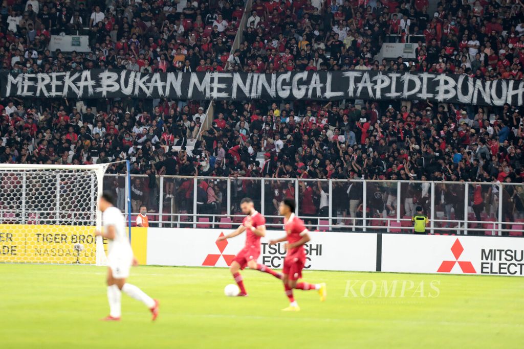 Penonton membentangkan spanduk yang mengkritisi penanganan kasus Kanjuruhan saat Indonesia menjamu Kamboja dalam pertandingan Grup A Piala AFF 2022 di Stadion Utama Gelora Bung Karno Jakarta, Jumat (23/12/2022). Indonesia menang 2-1. 
