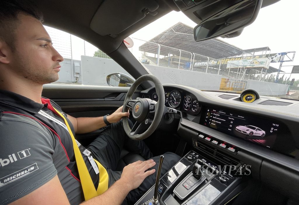 Paolo, instruktur di ajang Porsche World Road Show Indonesia 2023, menyetiri peserta dalam sesi <i>taxi ride </i>menggunakan model Porsche 911 Carrera GTS Coupe.