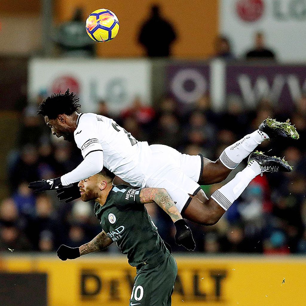 Striker Swansea City, Wilfried Bony, berebut bola atas dengan bek tengah Manchester City, Nicolas Otamendi, pada laga Liga Inggris di Stadion Liberty, Swansea, Kamis (14/12) dini hari WIB. Manchester City menang telak dengan skor 4-0.