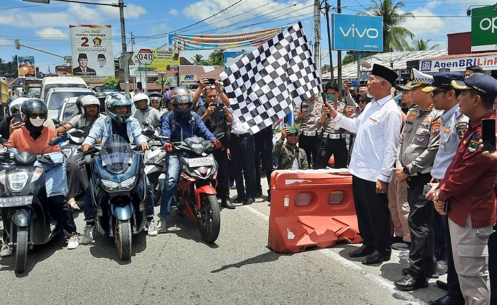 Gubernur Sumatera Barat Mahyeldi mengangkat bendera tanda pembukaan uji coba sistem satu arah di Jalur Padang-Bukittinggi di Sicincin, Padang Pariaman, Sumatera Barat, Sabtu (8/4/2023). 