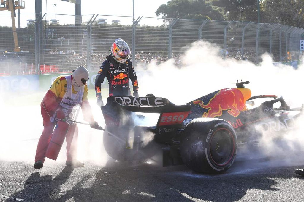 <i>Marshall </i>menyemprotkan pemadam api ringan ke mobil Red Bull RB18 disaksikan pebalap Red Bull, Max Verstappen (kanan), saat mobil Verstappen terpaksa keluar lintasan karena kerusakan jalur bahan bakar pada Grand Prix Formula 1 Australia di Sirkuit Albert Park, Melbourne, 10 April 2022.