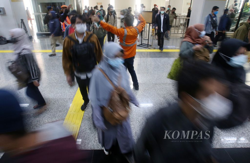 Petugas mengarahkan calon penumpang KRL Commuter Line di apron atas Stasiun Manggarai, Jakarta Selatan, Senin (30/5/2022). 