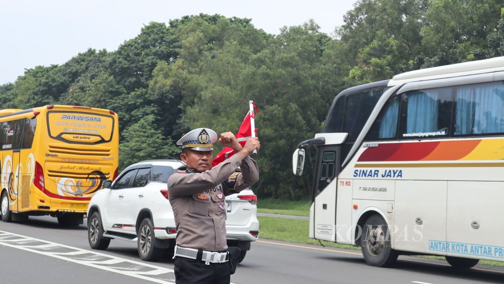 Petugas mengarahkan pengendara agar tidak memasuki Rest Area 207A, Tol Palimanan-Kanci, Cirebon, Jawa Barat, Selasa (18/4/2023) siang. Polisi dan pengelola jalan tol menerapkan sistem buka-tutup area istirahat untuk mengurai kepadatan saat arus mudik Lebaran.