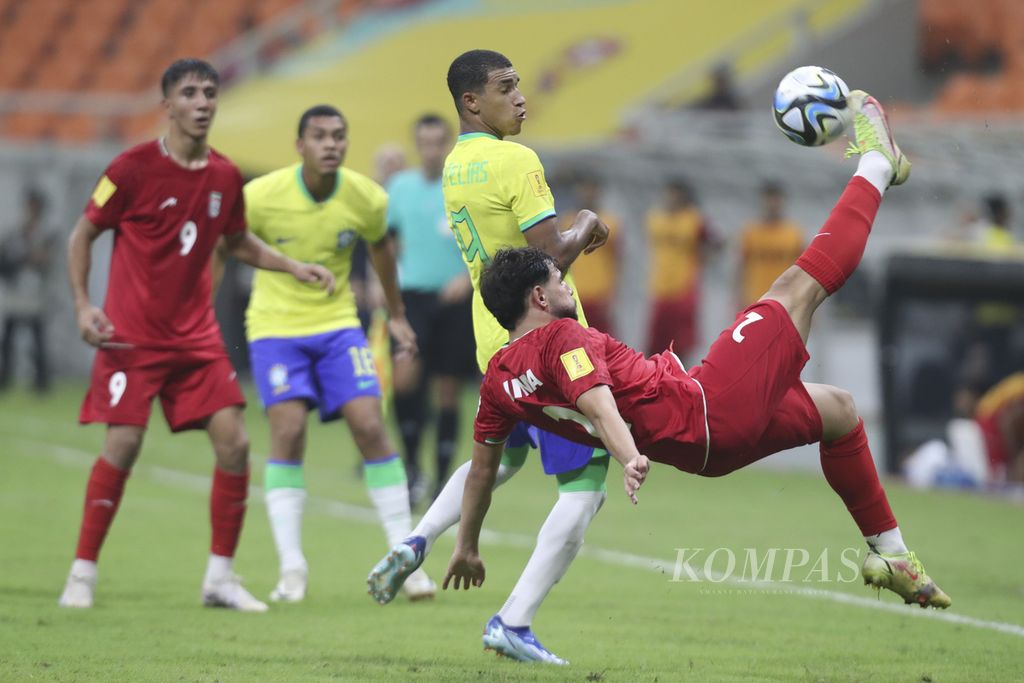 Pemain Brasil, Kaua Elias (belakang), berebut bola dengan pemain Iran, Nima Andarz, di pertandingan Grup C Piala Dunia U-17 2023 di Stadion Internasional Jakarta (JIS), Sabtu (11/11/2023). Iran menang 3-2 atas Brasil. 
