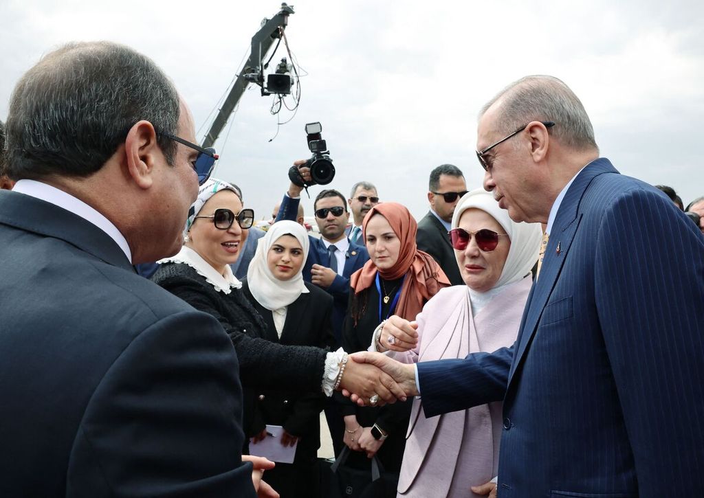 Dalam foto yang dirilis Kantor Pers Kepresidenan Turki pada 14 Februari 2024, Presiden Turki Recep Tayyip Erdogan (kanan) bersalaman dengan istri Presiden Mesir Abdel Fattah el-Sisi (kiri), Entissar Amer (kedua dari kiri), di samping istrinya, Emine Erdogan (kedua dari kanan), di Bandar Udara Internasional Kairo di Kairo, Mesir. 