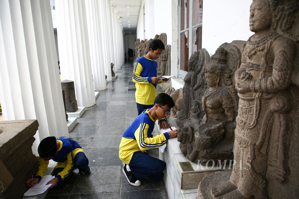 Siswa SMP Islam Al Fatah, Penjaringan, Jakarta Utara mengerjakan tugas sekolah dalam study tour ke Museum Nasional, Jakarta Pusat, Sabtu (14/3/2020). 