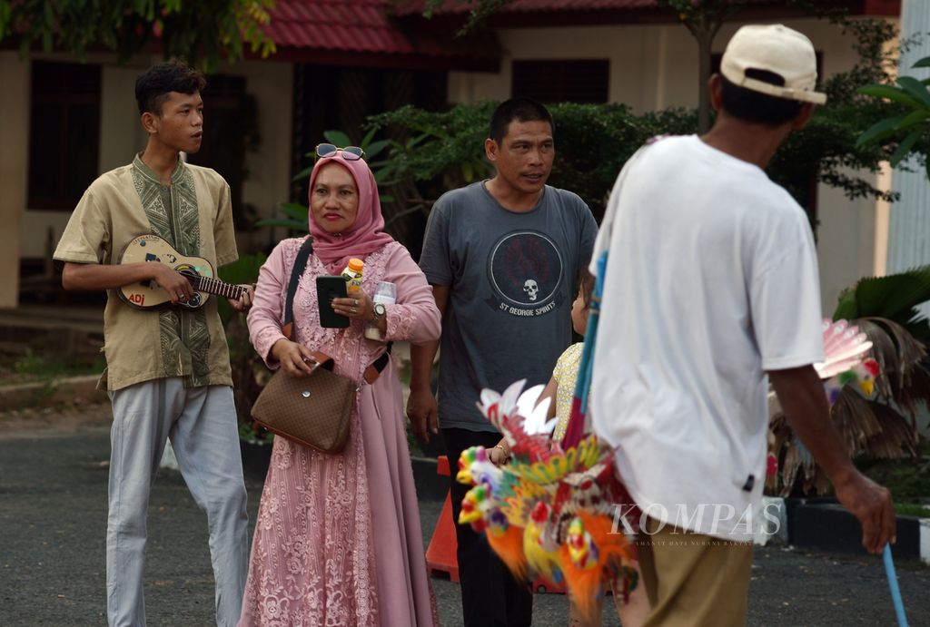 Wisatawan asal Ogan Komering Ulu Timur dikerumuni oleh pedagang kaki lima saat berkunjung ke halaman Museum Sultan Mahmud Badaruddin II, Palembang, Sumatera Selatan, Rabu (29/11/2023). 