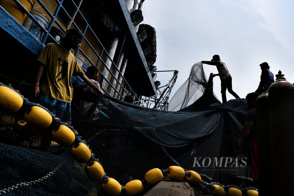 Anak buah kapal memindahkan jaring yang baru selesai diperbaiki ke dalam kapal penangkap ikan di Pelabuhan Perikanan Samudera Nizam Zachman, Muara Baru, Jakarta Utara, Rabu (18/5/2022). 