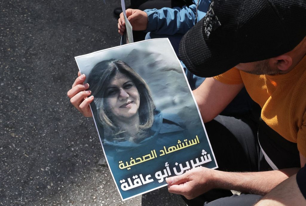 Seorang pria membawa poster bergambar jurnalis veteran Al Jazeera, Shireen Abu Akleh. di Jenin, wilayah pendudukan Tepi Barat, Rabu (11/5/2022). Abu Akleh tewas di tengah serangan tentara Israel terhadap salah satu kawasan di Jenin pada Rabu pagi. 