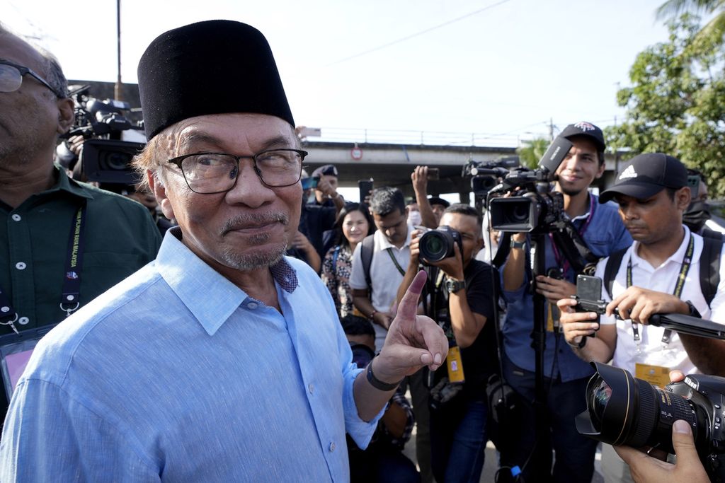Pemimpin oposisi Malaysia, Anwar Ibrahim, menunjukkan jarinya yang sudah dicelup tinta kepada awak media setelah memberikan suara di tempat pemungutan suara di Seberang Perai, Negara Bagian Penang, 19 November 2022. 