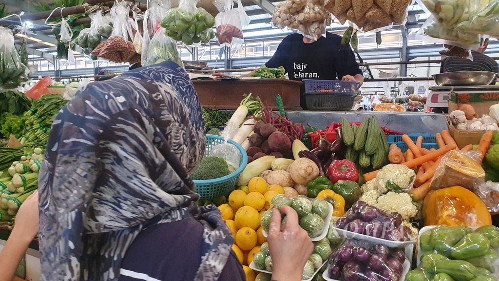Seorang pembeli membeli sayur di pasar Bintaro, Tangerang Selatan, Minggu (31/3/2024).
