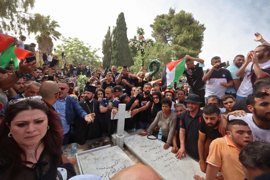 Ribuan warga dan pelayat mengantarkan jenazah jurnalis veteran Al Jazeera, Shireen Abu Akleh, ke Tempat Pemakaman Gunung Zion di luar Kota Tua Jerusalem timur, Jumat (13/5/2022). 