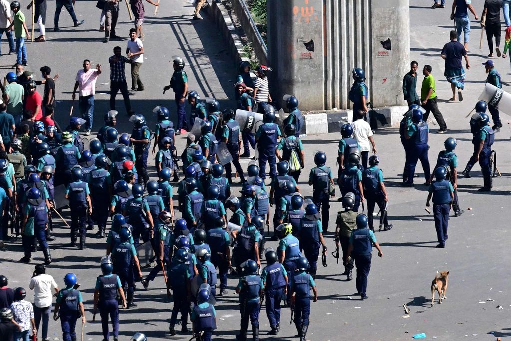 Personel polisi Bangladesh menghadapi para pengunjuk rasa dalam demonstrasi di Dhaka, Minggu (4/8/2024). 