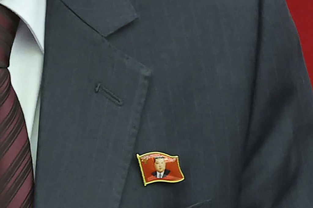 Seorang pejabat senior tampak mengenakan pin kerah bergambar Kim Jong Un saat pertemuan partai berkuasa di Pyongyang, Minggu (30/6/2024).