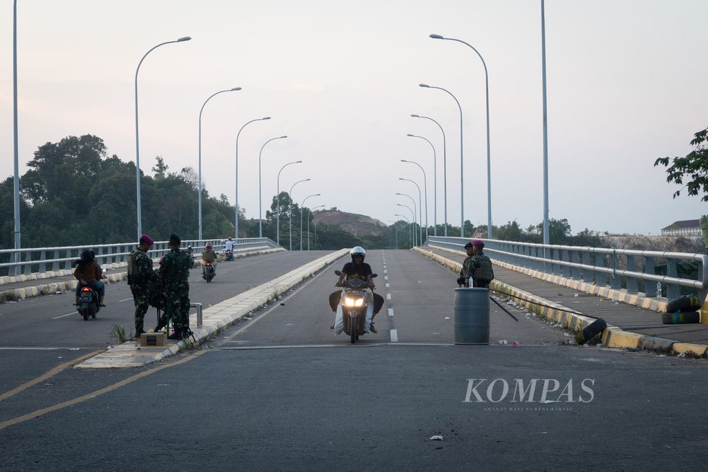 Seorang pengendara sepeda motor melintasi pos penjagaan aparat di Jembatan Batam-Rempang-Galang (Barelang) IV di Pulau Rempang, Batam, Kepulauan Riau, Jumat (8/9/2023). Pascabentrok dengan warga, aparat mendirikan tujuh pos pengamanan di Rempang.