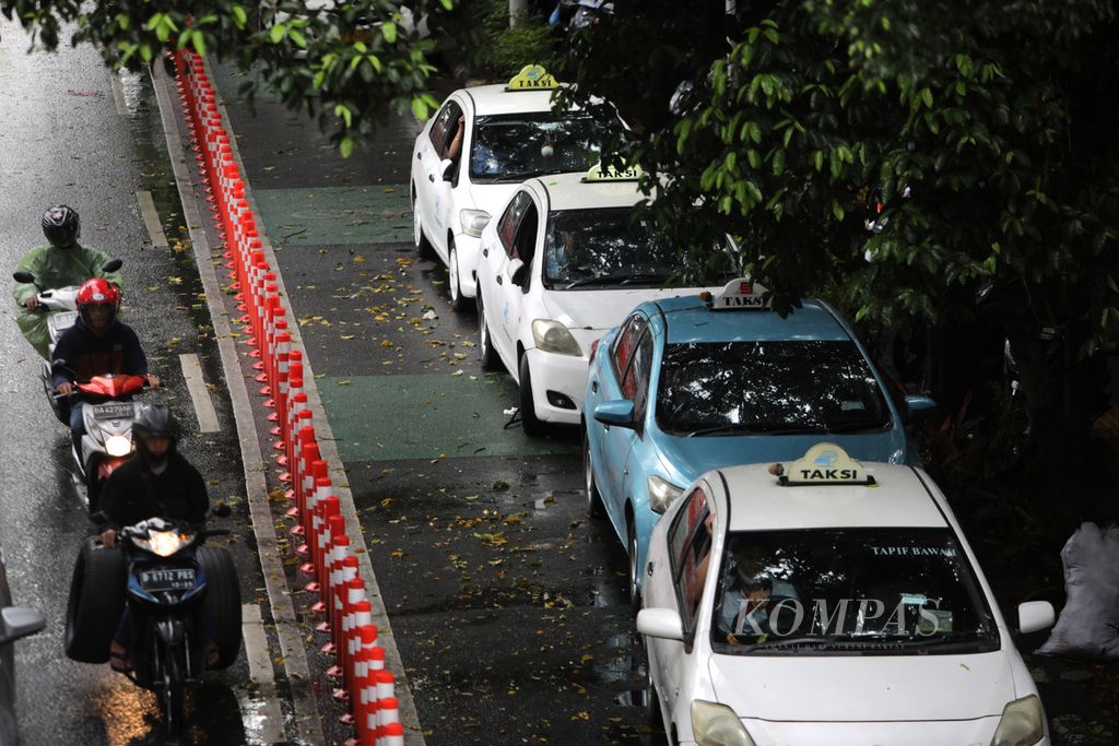 Taksi diparkir pengemudinya sembari menunggu penumpang di lajur sepeda di Jalan Tentara Pelajar, Jakarta, Kamis (9/2/2023). 