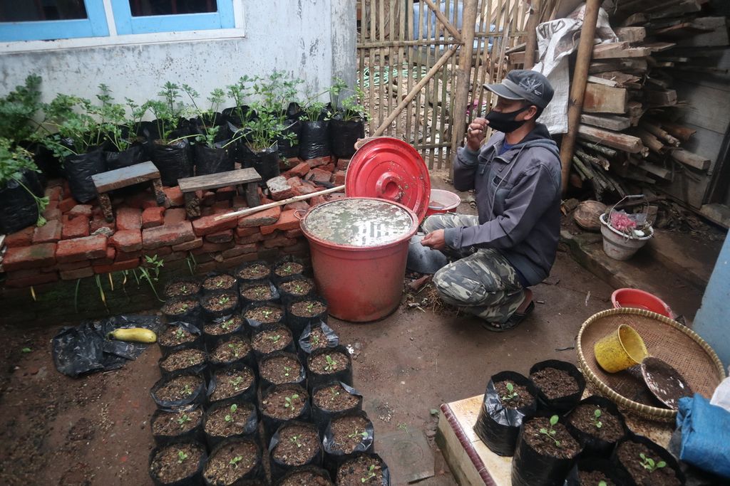 Suryana (51) menunjukkan pupuk kompos di rumahnya di Desa Nangka, Kecamatan Kadugede, Kabupaten Kuningan, Jawa Barat, Rabu (16/12/2020). Pupuk itu berasal dari berbagai bahan, seperti kotoran kambing dan air beras. Pupuk tersebut diberikan ke tanaman sayurannya di depan ruamhnya.