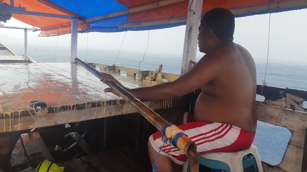Roni, pengemudi perahu motor yang ditumpangi wartawan <i>Kompas,</i> Pati Herin, Sabtu (18/12/2021). Perahu yang dikemudikannya berlayar dari Pulau Babi ke Pulau Flores.