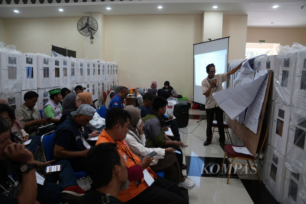 Anggota Panitia Pemilihan Kecamatan membuka lembaran hasil penghitungan suara TPS untuk dicatat dalam rekapitulasi hasil penghitungan suara tingkat kecamatan di GOR Duren Sawit, Jakarta Timur, Sabtu (17/2/2024).  