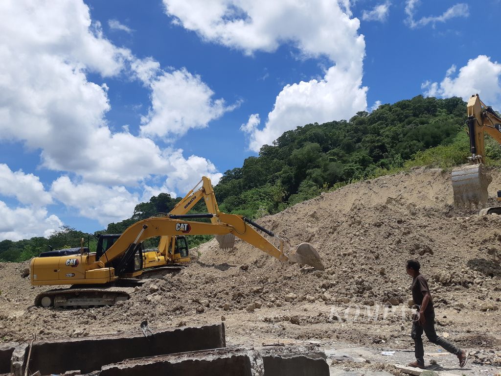Ekskavator terus membersihkan material longsoran di ruas jalan Timor Raya, tepatnya di Kelurahan Takari, Kabupaten Kupang, Nusa Tenggara Timur pada Minggu (19/2/2022). Diperkirakan paling cepat dalam satu minggu jalur itu sudah bisa dilewati.