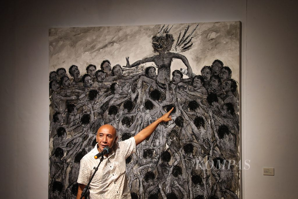 Putu Sutawijaya menunjuk karyanya saat menyampaikan sambutan dalam pembukaan pameran Lelampah oleh Putu Sutawijaya di Bentara Budaya Jakarta, Kamis (14/9/2023).